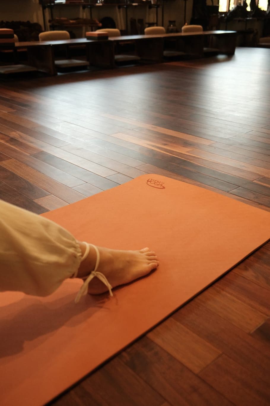 Thảm Yoga Mermaid Pro Mat — mặt thảm màu đất nung trên sàn gỗ