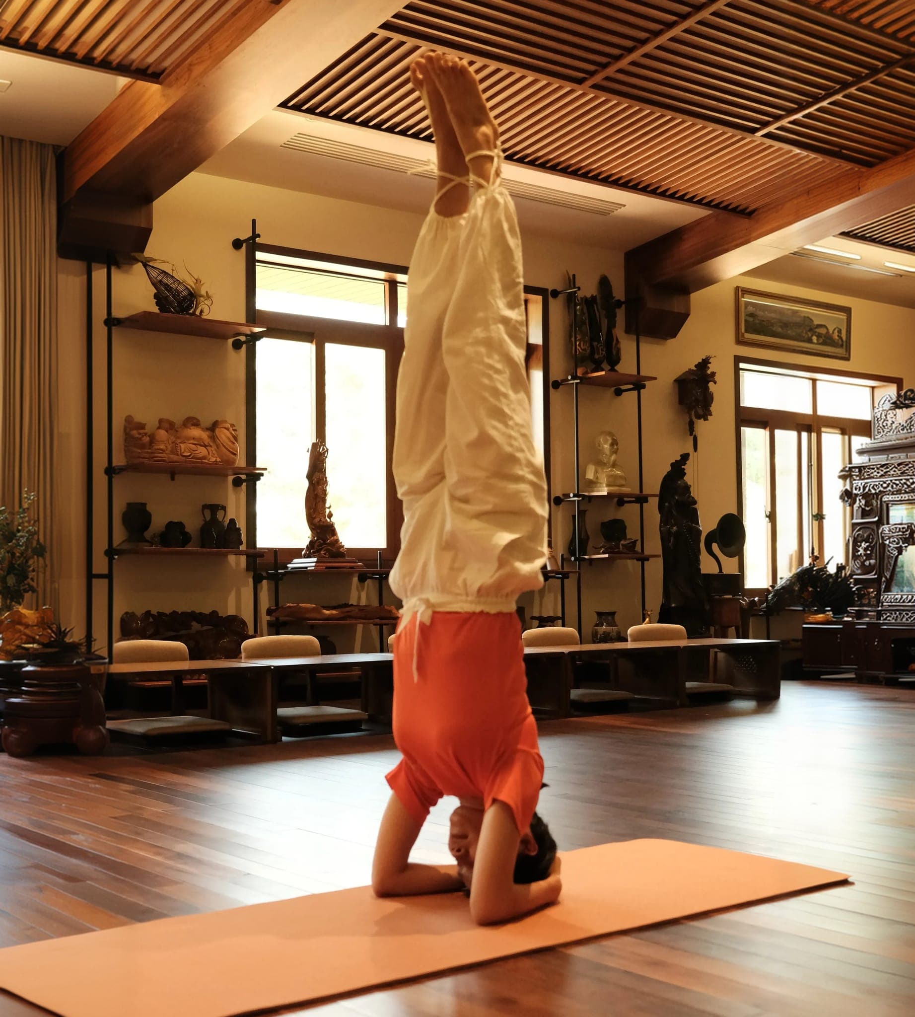 Học viên tập tư thế đứng bằng đầu tại studio Mermaid Yoga